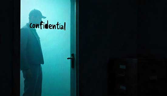 Man standing behind foggy glass with "Confidential" written on it